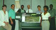 K&T CAD and GIS staff standing in front of the new HP 1050C plotter, supplied by Allyson Lawless and used to plot high quality colour plots